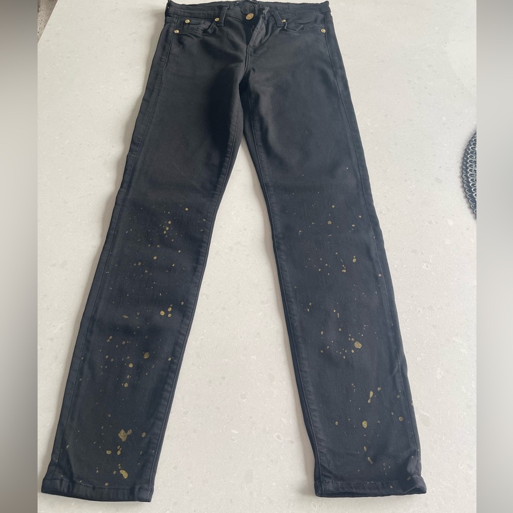 True black Skinny 7 for All Man Kind with gold splatter paint on lower legs.